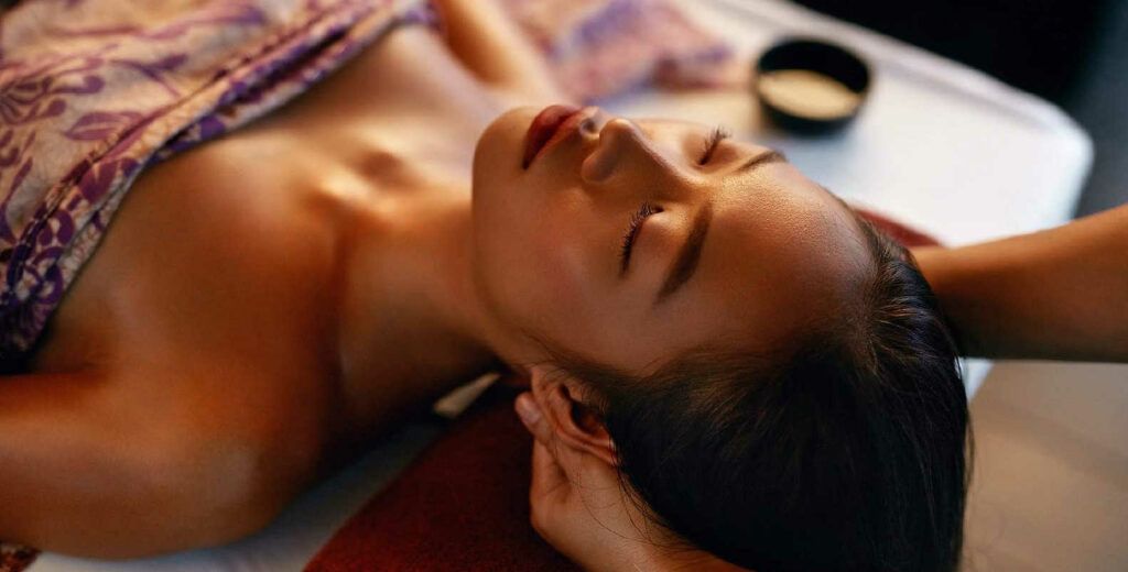 Massage shiatsu sur une jeune femme avec appuis sur la tète