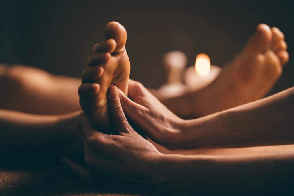 Massage du pied avec huile sur table de massage appelé Réflexologie plantaire à Le Mans