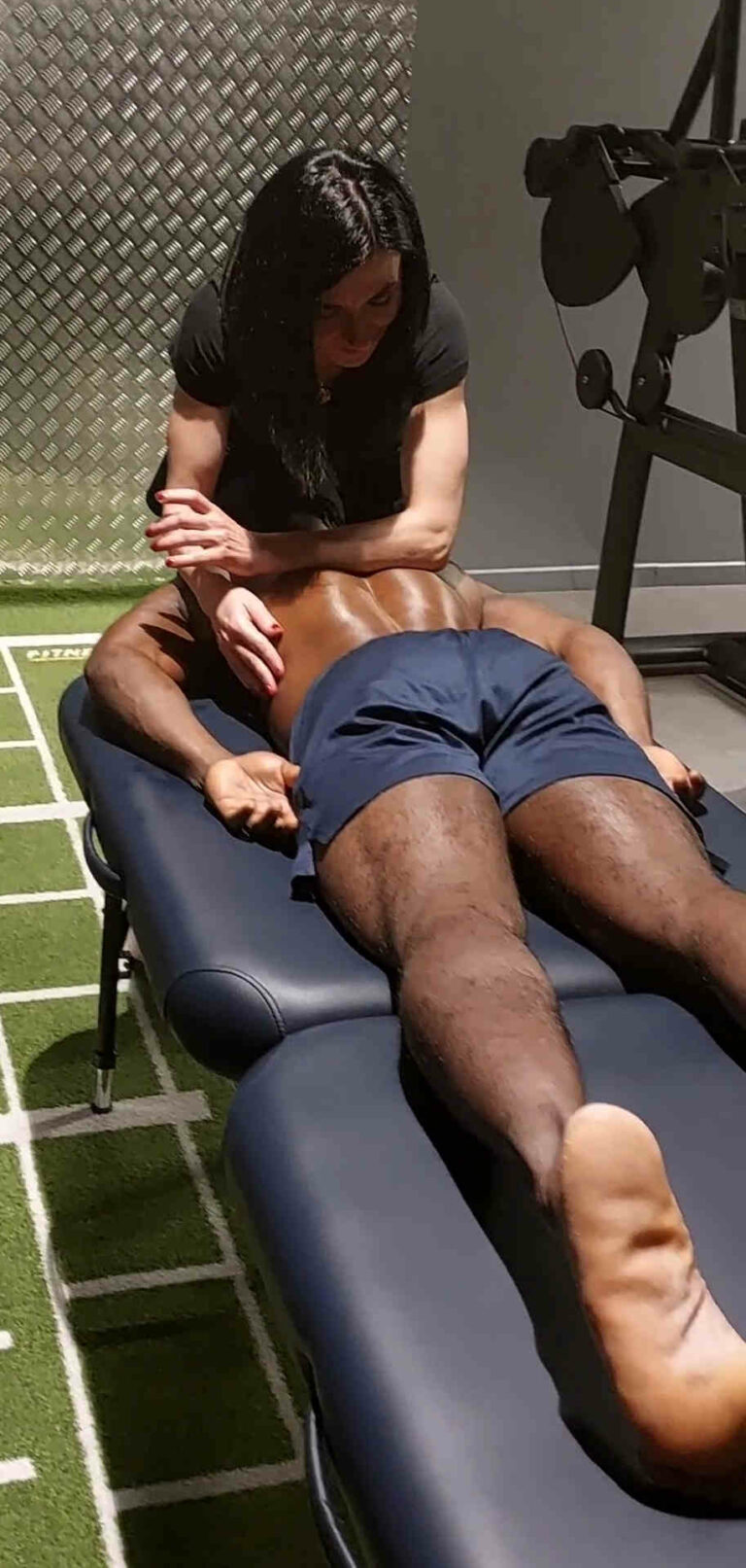 Massage sportif du dos et trapèze d'un athlète après effort